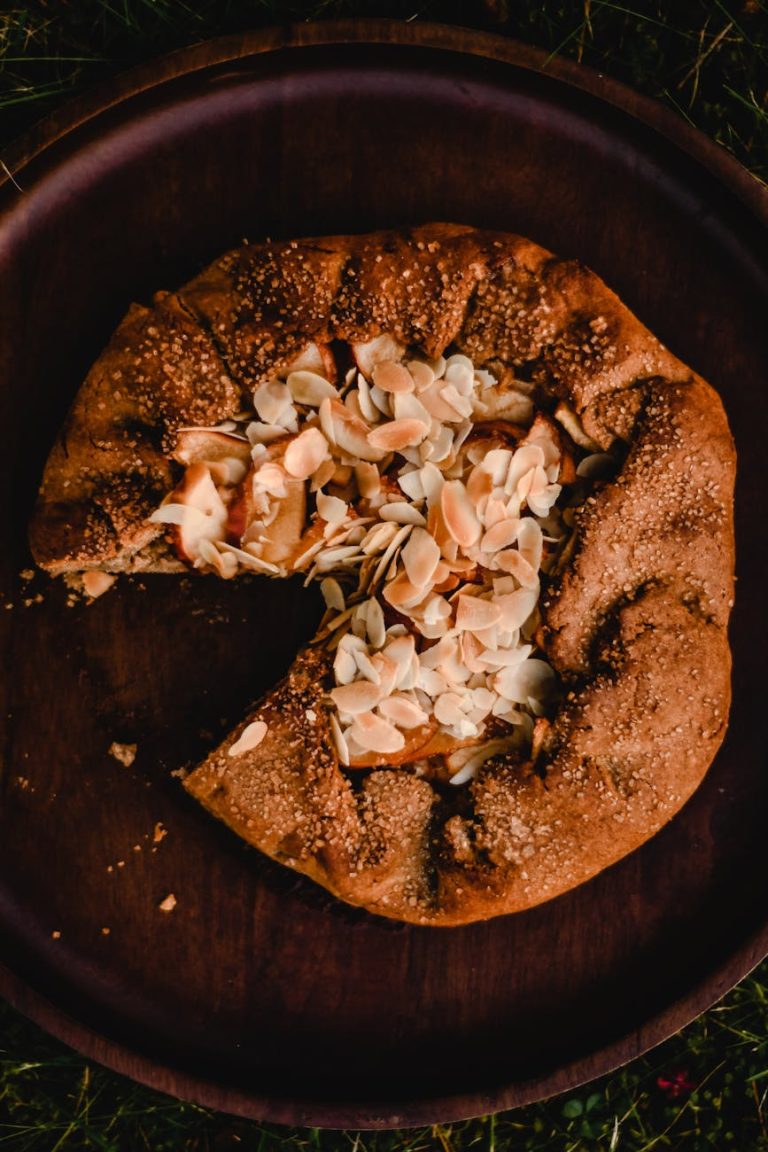 Delicious rustic almond galette on a wooden plate, perfect for dessert lovers.