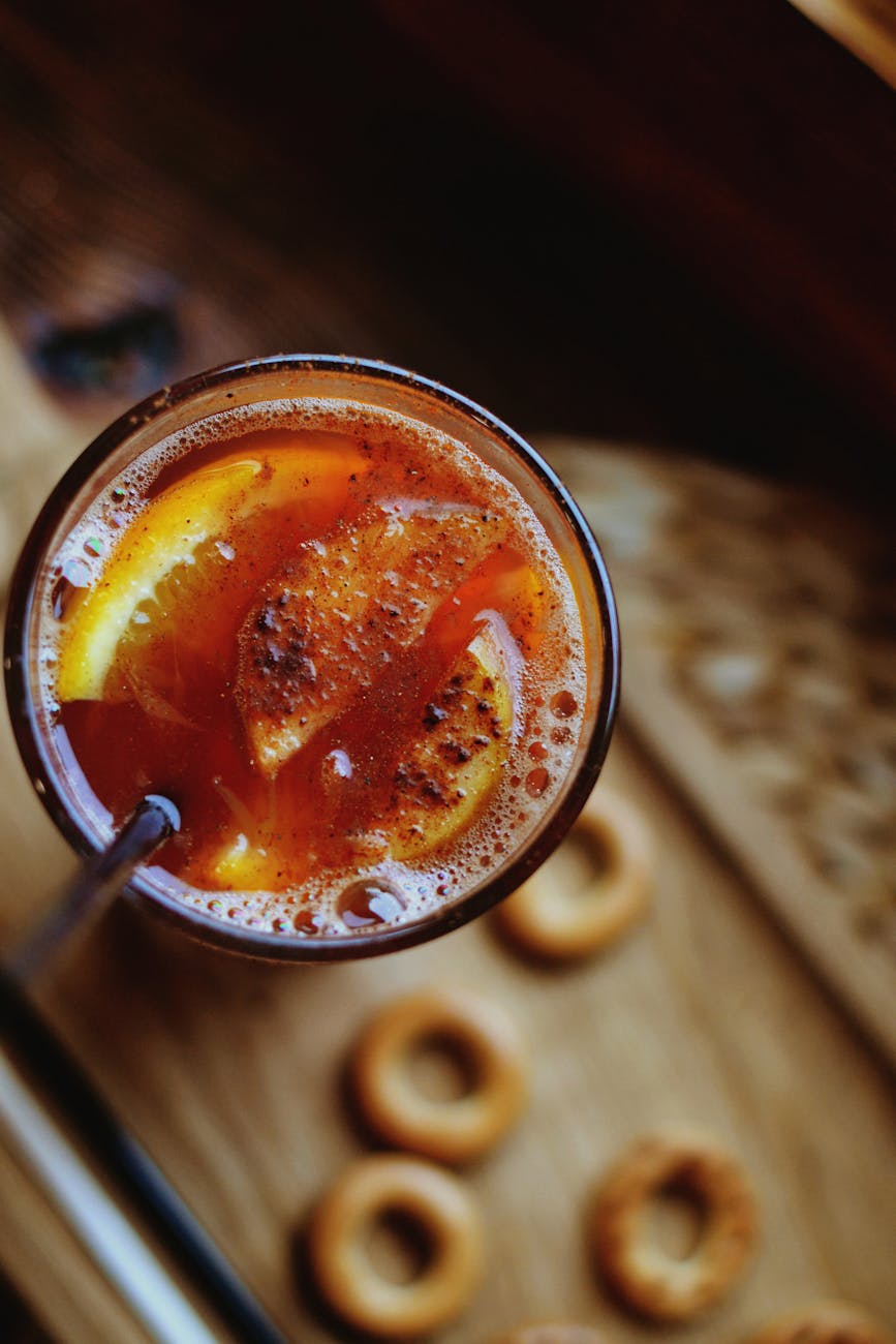 Top view of a spiced citrus drink in a glass with a straw, perfect for any occasion.