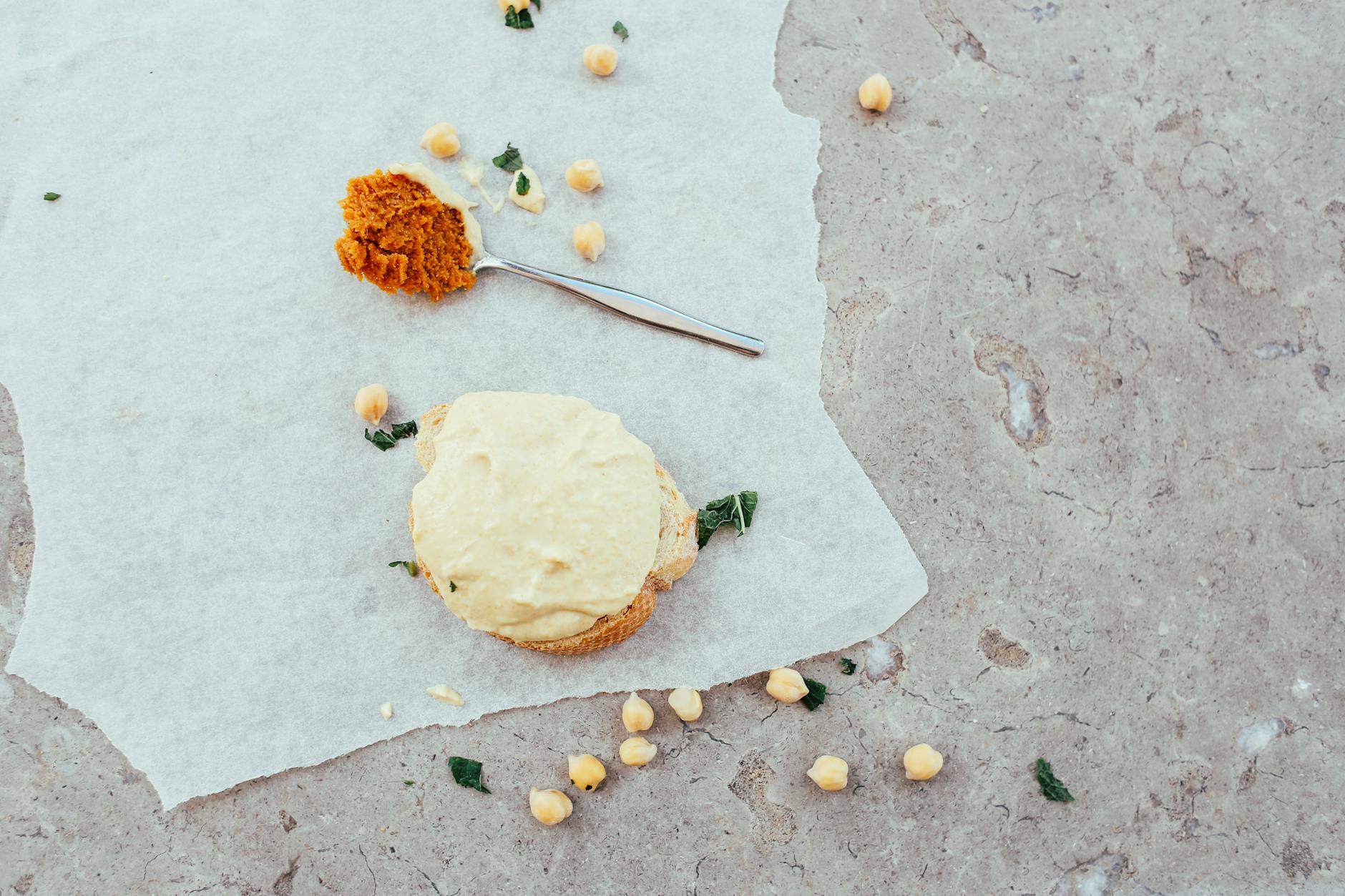 Delicious chickpea bread slice with spices and garnish on parchment paper, photographed top view.