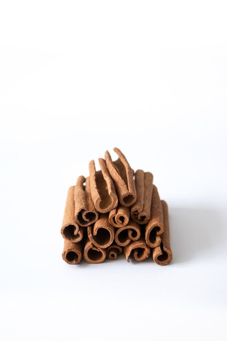 A stack of aromatic cinnamon sticks arranged on a white background, perfect for culinary and spice themes.