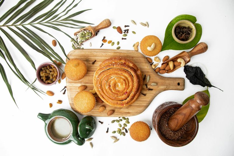 Aesthetic flat lay featuring homemade bread, muffins, and assorted spices on a wooden board.