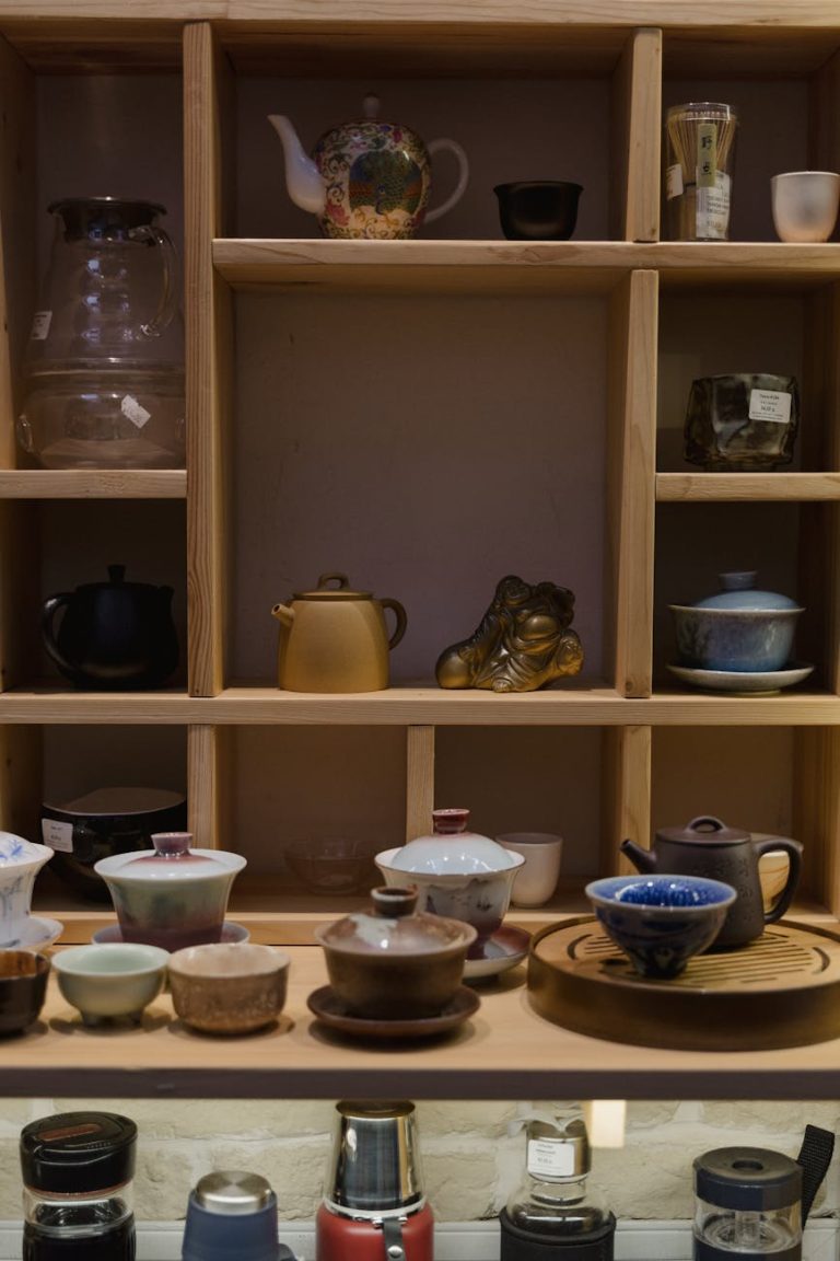 A beautifully arranged collection of traditional tea sets and utensils on wooden shelves.